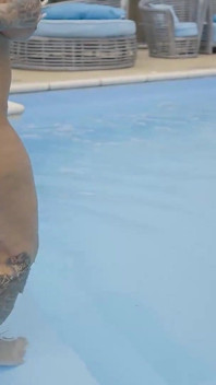 Grandota con grandes tetas y uñas largas masturbándose en la piscina
