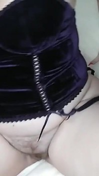 Bujna dziewczyna w gorsecie bawi się dildo