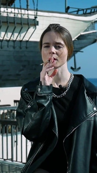 Mladá ruská žena kouří cigaretu na venkovní terase