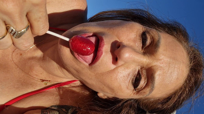 Melissa Johnson: Мелісса Джонсон смокче і облизує вишневий льодяник на пляжі
