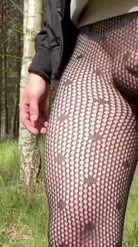 Walking in a park in fishnet tights.