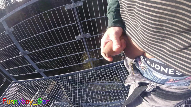 Funnyboy-Ger: Utomhus, på ett mycket offentligt utsiktstorn vid en flod, arbetar...