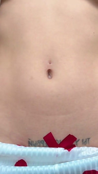 Slanke leerling speelt met haar navel en plaagt haar magere buik
