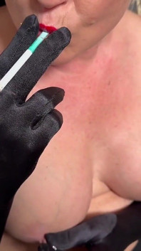 Fumer dans des gants de rouge à lèvres et de satin