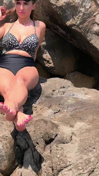 Pés provocando na praia selvagem