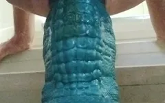 La trav si accovaccia e allunga sul dildo enorme