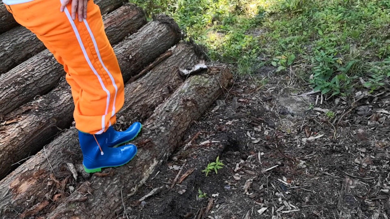 Bouncy Tits Action: Sitzen in gummistiefeln auf woodpile