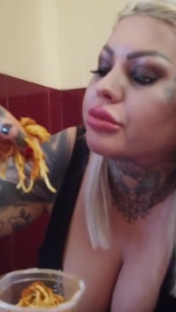 Blonde tätowierte milf isst spaghetti auf der toilette