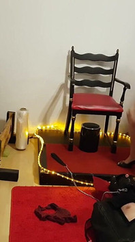 가죽 노예에게 얼굴을 내미는 매력적인 Dominatrix