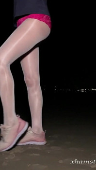 Anna en collants blancs brillants sur la plage nocturne