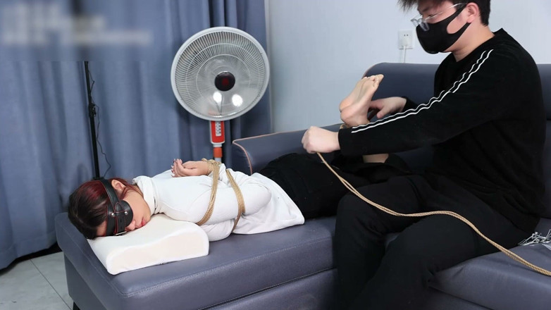 Asian bondage: Die extremen Fesseln eines barfüßigen Mädchens, das mit ihren nackten...