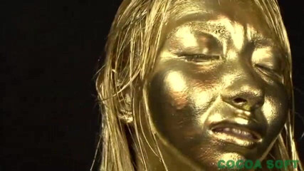 Cocoa Soft: A beautiful woman is exercising with full body gold