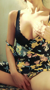 Hübsche frau masturbiert vor der kamera in einem kleid und bringt sich zu einem lauten orgasmus mit ihren fingern.