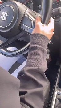 Mijn geliefde speelt met zijn voeten op de pedalen van zijn auto