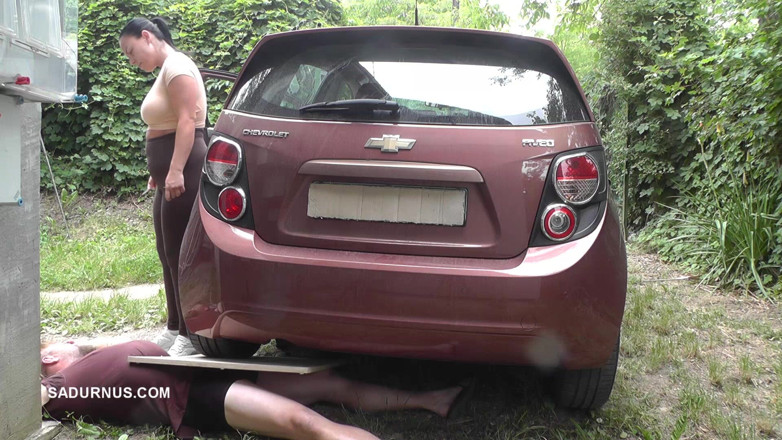 Sadurnus: Mistress Jenna Stands on the Slave with a Car While...