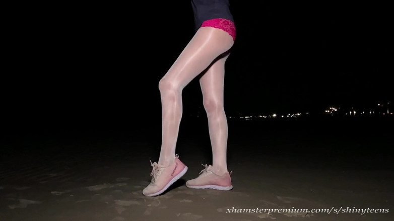 Shiny teens: Anna in collant bianchi lucidi sulla spiaggia di notte