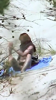 La bellezza rossa si infila un dildo nella figa sulla spiaggia sabbiosa
