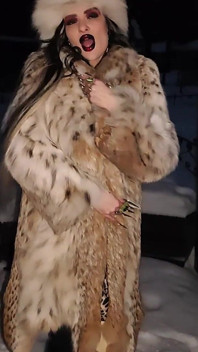 一个哥特式女巫在冬季暴风雪中用她的黑色魔法仪式，长指甲和毛皮勾引你。