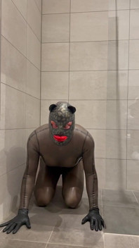 Combinaison en latex transparent noir dans la salle de bain