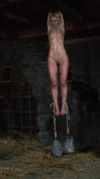 Blonde Girl Has Weights Attached to Her Feet and Is Hoisted up for Whipping