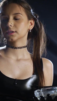 Si rambut coklat merokok dalam pakaian lateks hitam adegan sensual perlahan