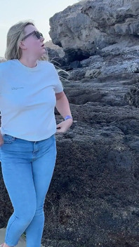 Kissa i tighta jeans på stranden