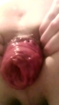 Um jovem cara gostoso sentado em uma cadeira mostra seu prolapso anal