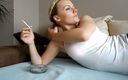 Femdom Austria: Блондинка-тінка у нижній білизні лежить на ліжку, курячи сигарету