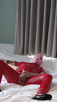 Curvă sexy mascată pentru spermă în costum de pvc roșu complet