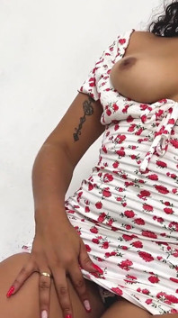 Ein kurzes blumiges kleid zu tragen und heißen zu haben