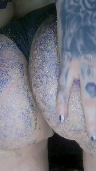 Chica alternativa con aceite masajeando un y nalgadas por glitters