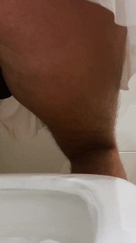 Crossdresser với một cái mông to trong một chiếc váy ngắn đang đi tiểu