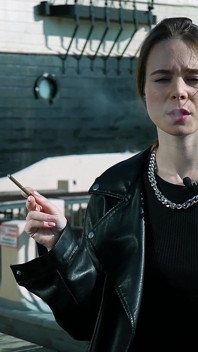 Giovane donna russa che fuma sigaretta sulla terrazza all'aperto