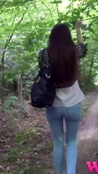 Desperate Brunette with Long Legs in Tight Jeans Walking Trough Forest Searching for a Place to Pee