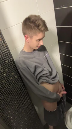 Knappe kerel Asta jongen trekt zich af en komt klaar in een openbaar toilet