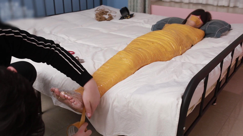 Asian bondage: Una dolce ragazza scalza usa del nastro adesivo per legare...