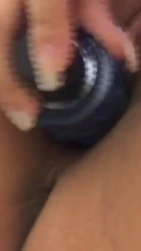 The horny brunette enjoys masturbating with her Sex Toy on the bed