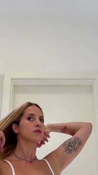 Frumoasa profesoară de yoga blondă sexy într-o rochie mini transparentă pe jumătate merge goală în baie