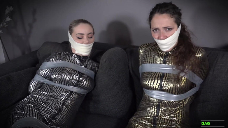 Gag Attack: Aubrey et Julia - combinaison en bondage sur bande