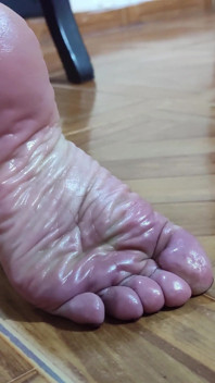 小さな足のしわだらけの足の裏と大きく開いたお尻