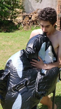 Bell'uomo gonfia la sua balena gonfiabile vicino alla piscina fuori