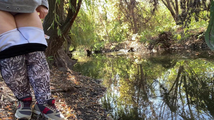 Thumbnail of MILF dressed in leggings pissing in the river