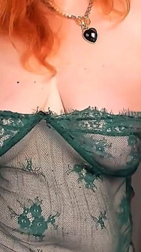 Şeffaf zümrüt elbiseli olgun kızıl saçlı kadın 50+ striptiz