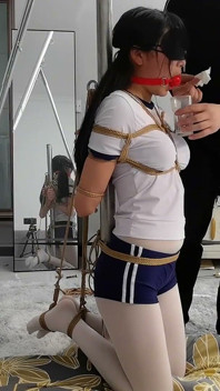 La novia con medias blancas estaba atada a un poste de hierro con cuerda, las piernas suspendidas y los vibradores cosquilleados por todas partes