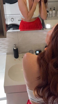 Une vraie femme rousse sexy vêtue de bas résille sexy avec une courte minijupe exhibe sa chatte et son gros cul