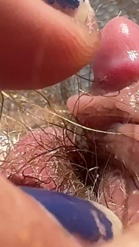 Fată păroasă amatoare se masturbează în prim-plan cu clitoris uriaș