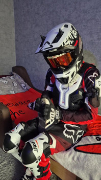 バイクのギアを着た興奮した男がスニーカーを犯す