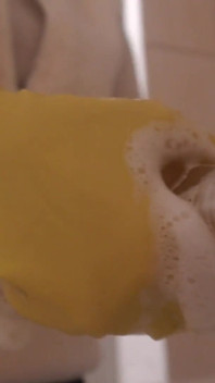Minha meia-irmã em luvas amarelas de lavagem de pratos toma um banho com um vibrador e muita espuma branca e sabão