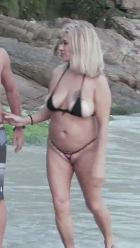 Blondeliberal cu minibikini care arată păsărica, în mijlocul bărbaților și se fute cu prietenul în fața lor