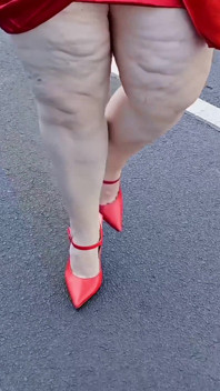 Bela mulher andando ao ar livre no estacionamento se exibindo para estranhos